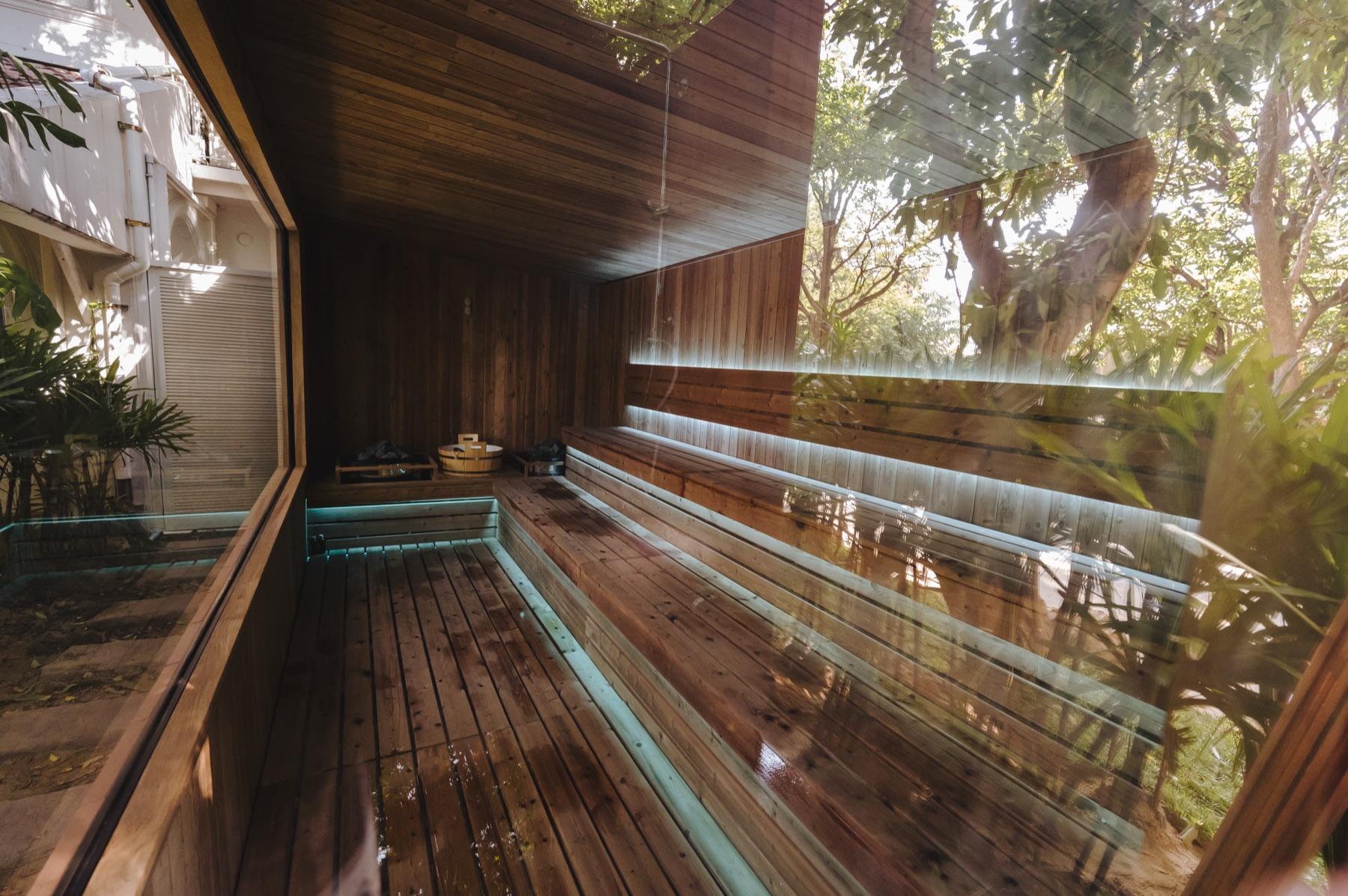 Timber benches and garden-facing glass inside the Finnish-style sauna